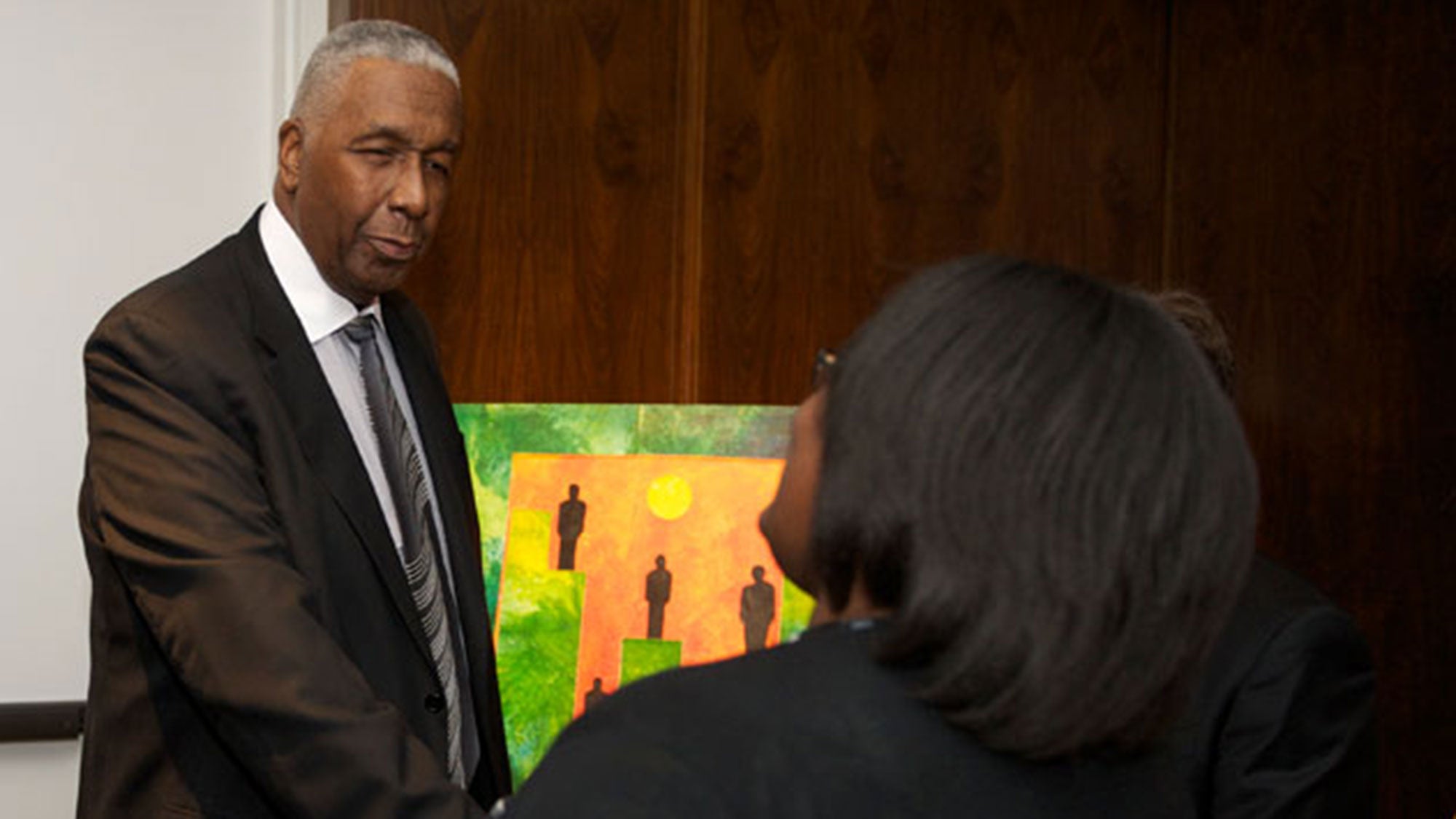 John Thompson Jr. speaks with a woman at a local Boys & Girls Club.