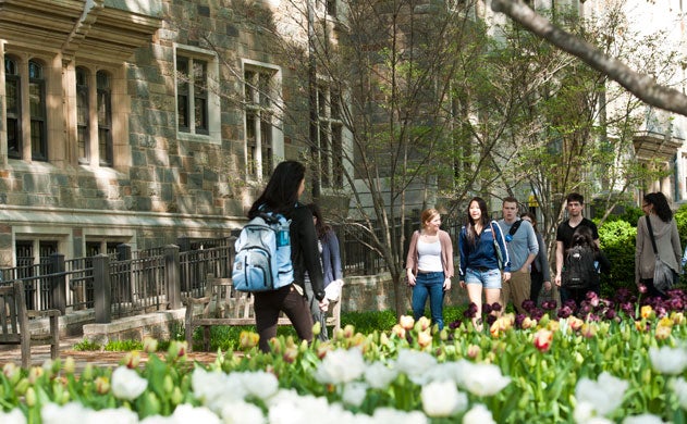 Students with backpacks walking outside on campus.