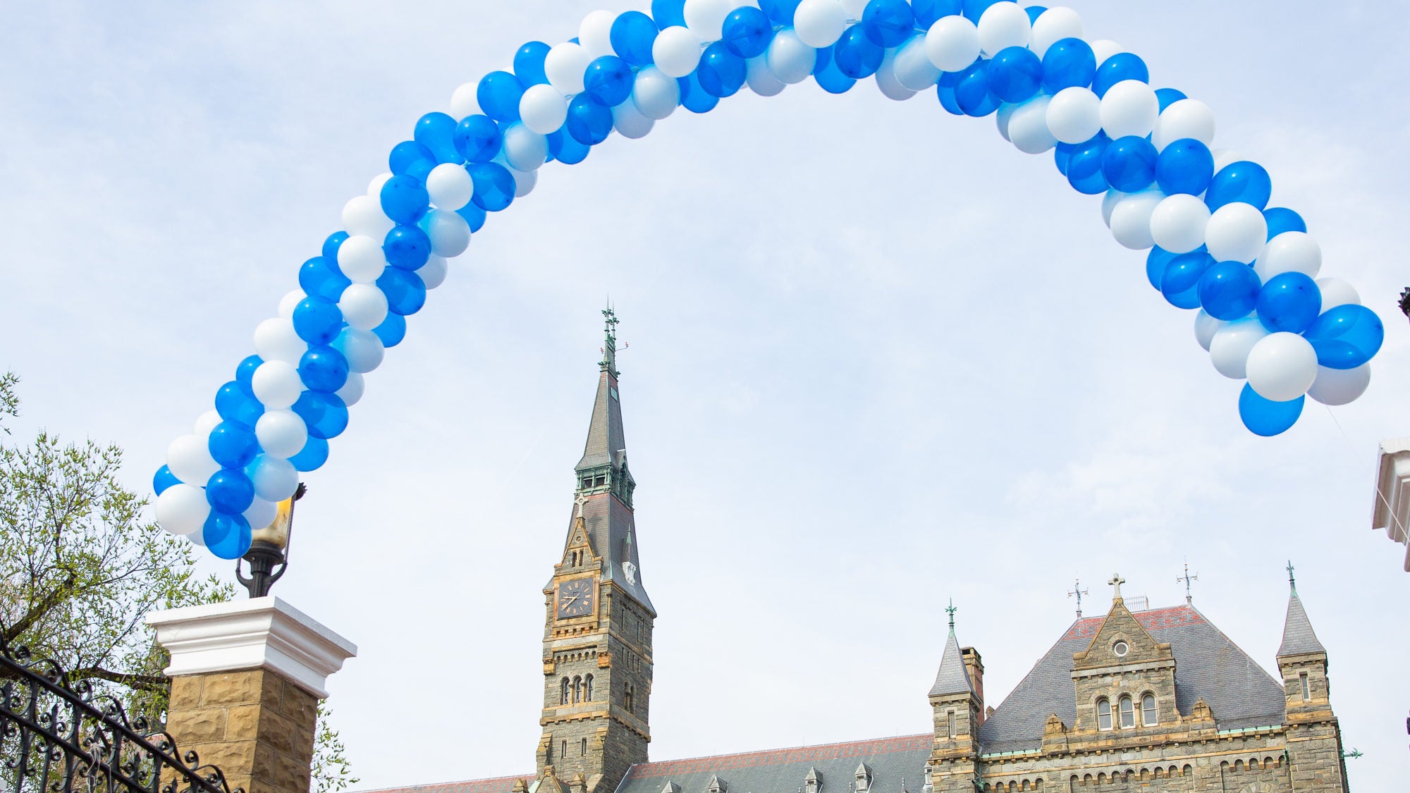 A white and blue balloon arch floats above the front gates on Georgetown&#039;s campus.