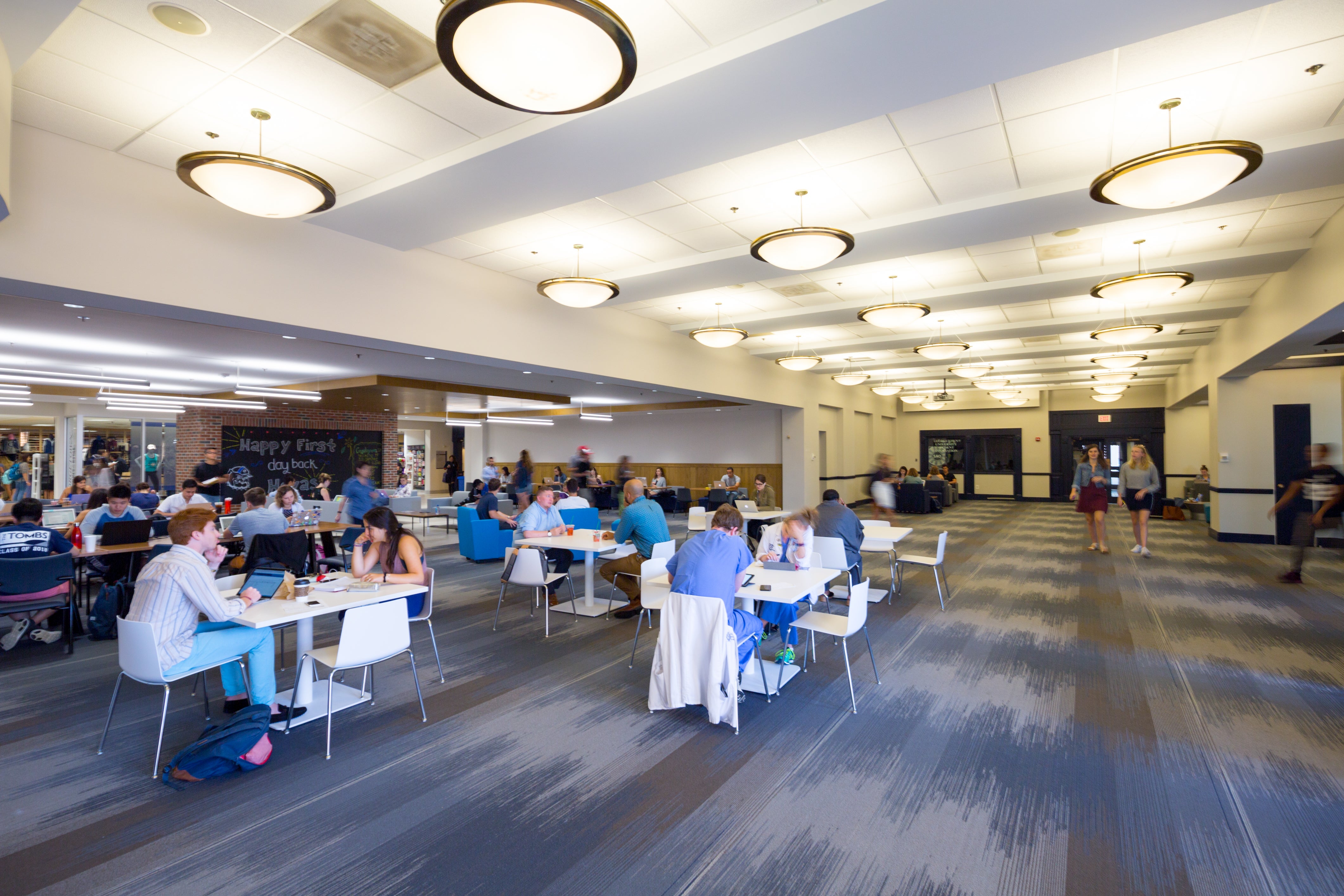 Students are pictured studying in the Leavey Center at different tables.