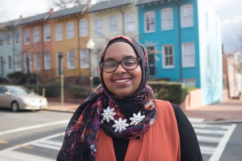 Khadija Mohamud smiles for the camera in front of the street.