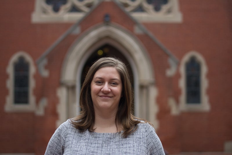 Emma Curran smiles for the camera in front of a chapel.