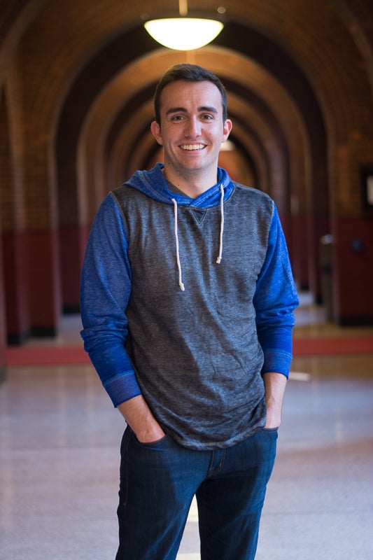 Connor Maytnier smiles for the camera in a hallway.