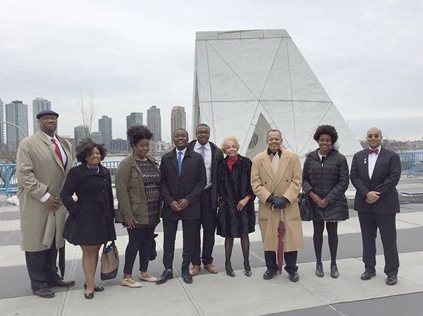 Descendants and other members of the Georgetown community stand before a sculpture at the United Nations in New York