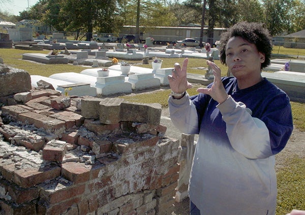 Jessica Tilson gesturing with hands in a cemetery where her ancestors are buried