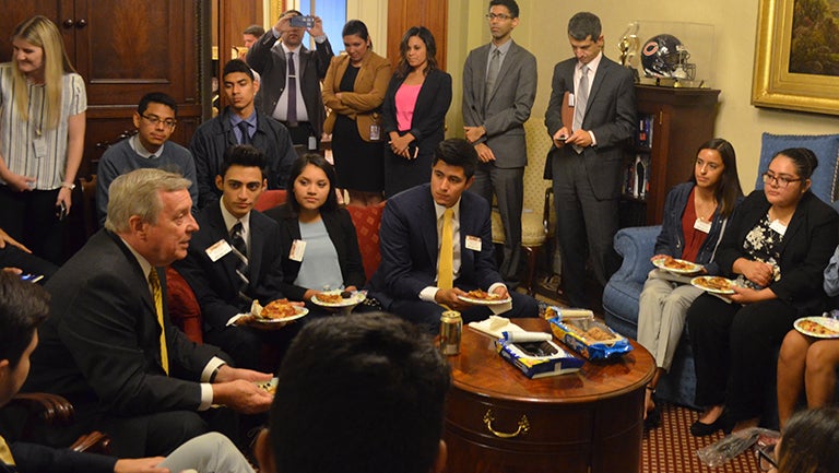 Sen. Richard Durbin sitting in his office on Capitol Hill surrounded by Georgetown undocumented students and others