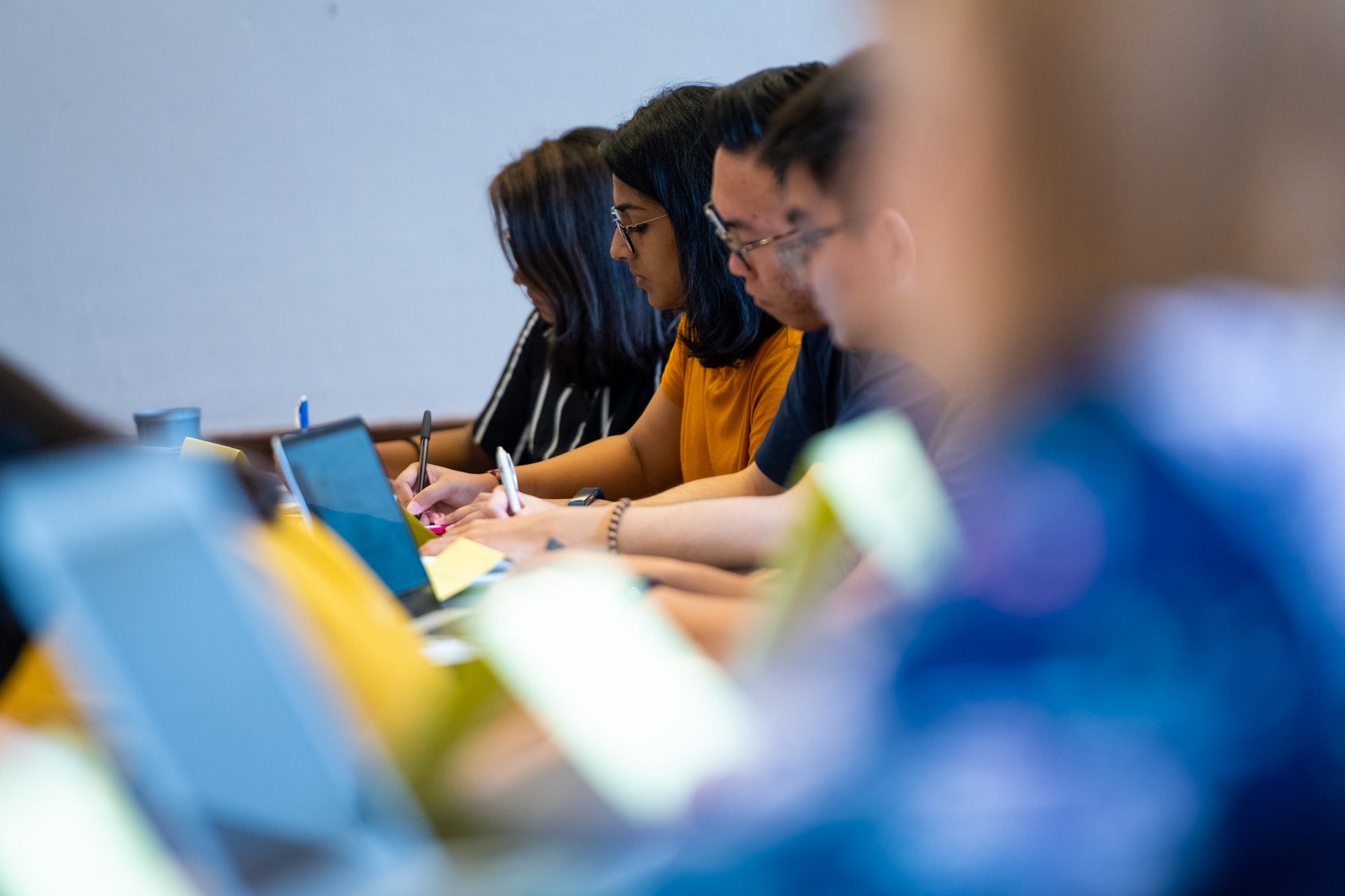 Students in a row take notes in a class at Georgetown