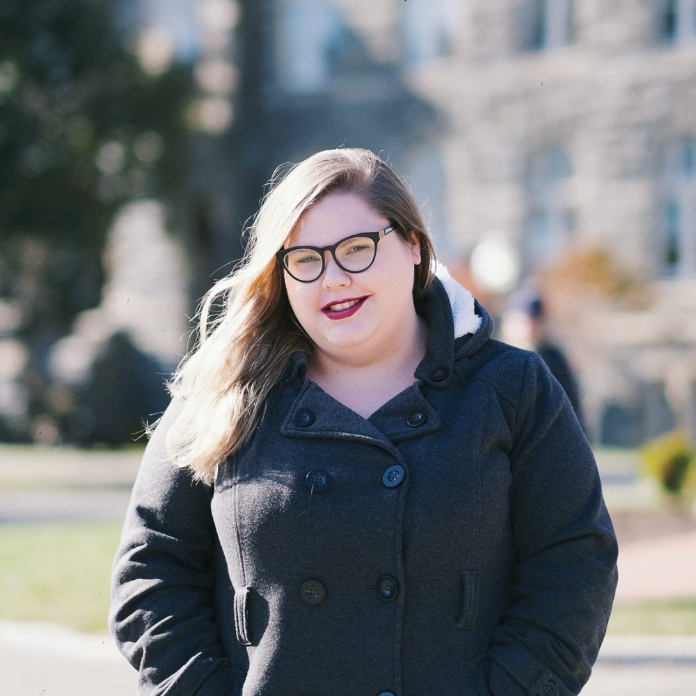 Amanda Scott smiles for the camera on the front lawn.