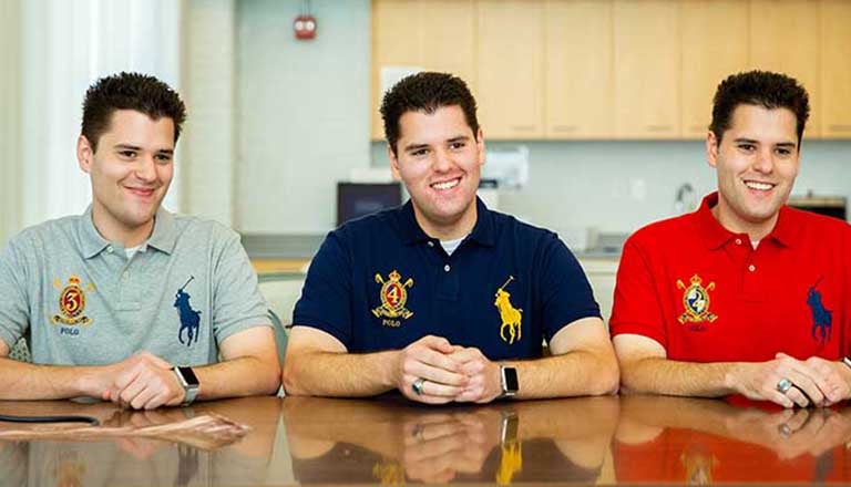 Triplets Nicolas, Zachary and Benjamin Osborne sitting next to one another