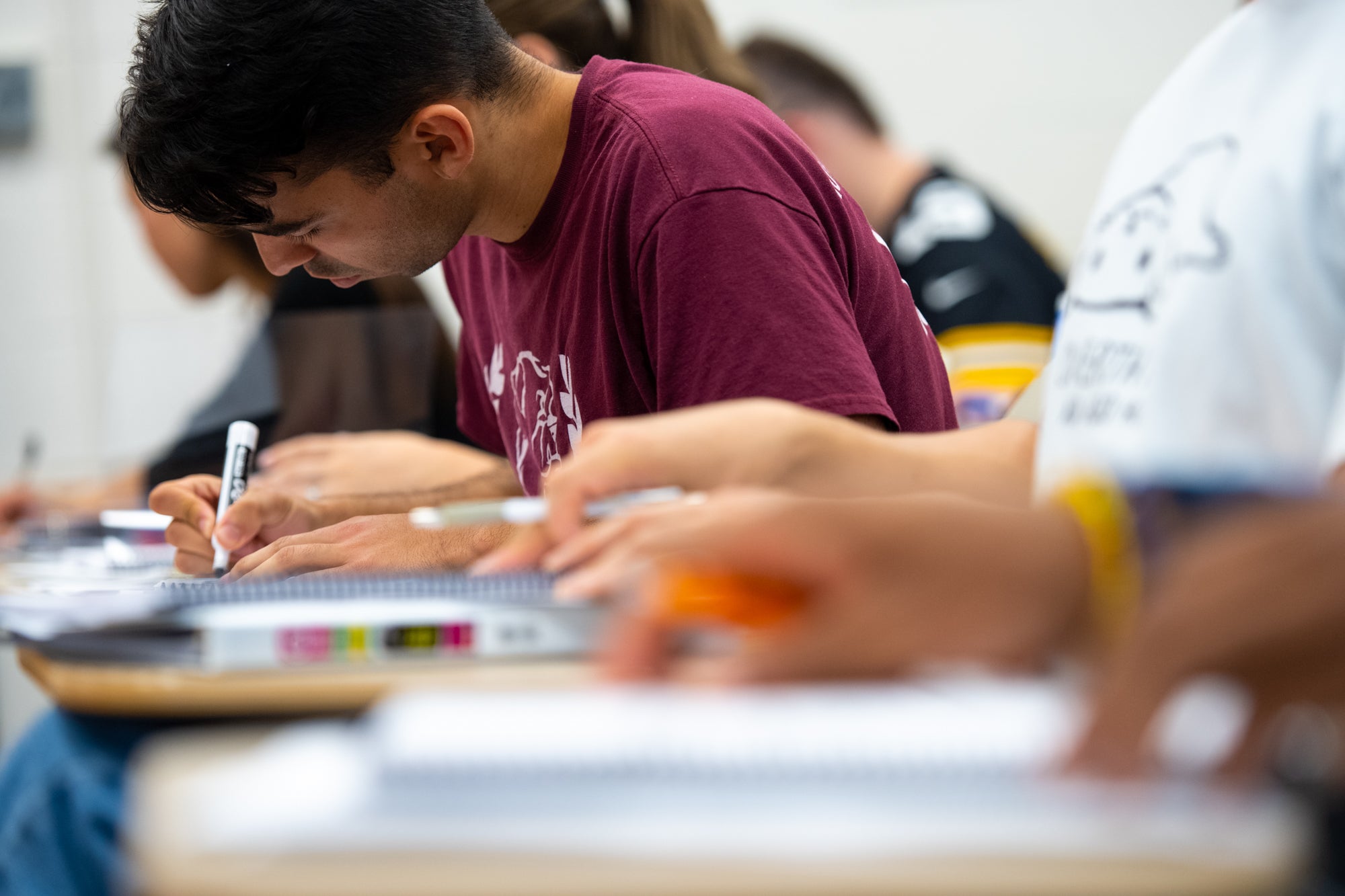 A student leans over his notebook in a Georgetown classroom