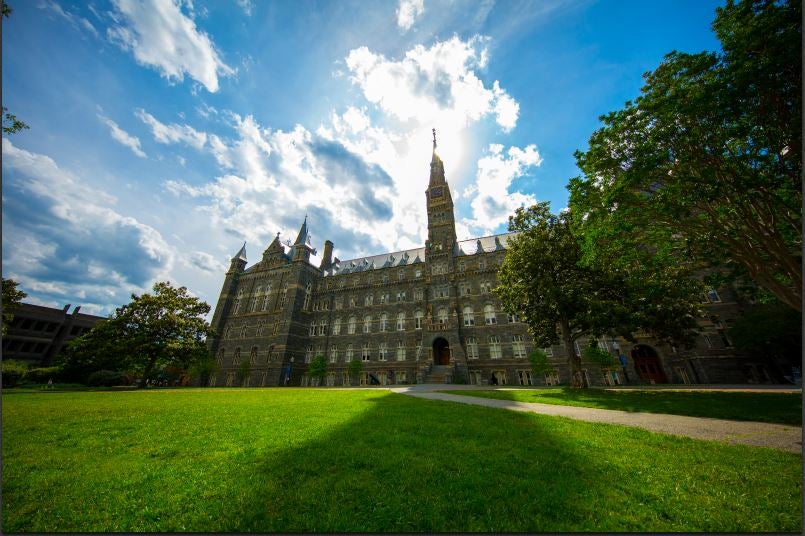 Healy Hall with green lawn and blue sky and fluffy clouds behind it