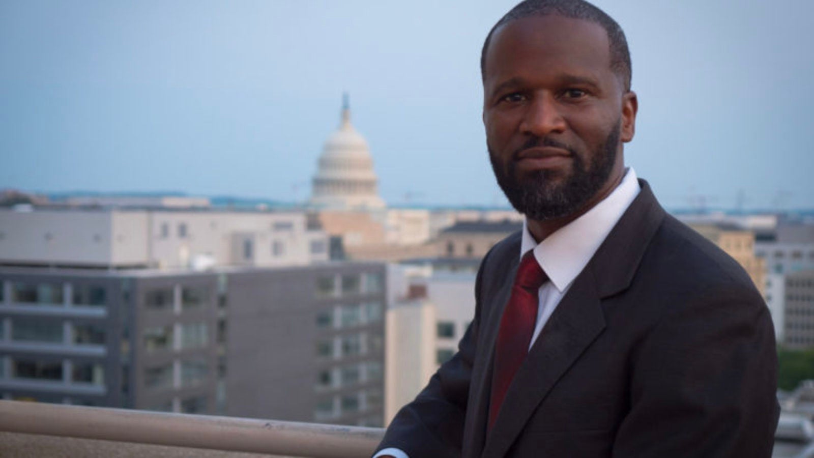 Ty Pinkins stands outside with the U.S. Capitol building in the background.