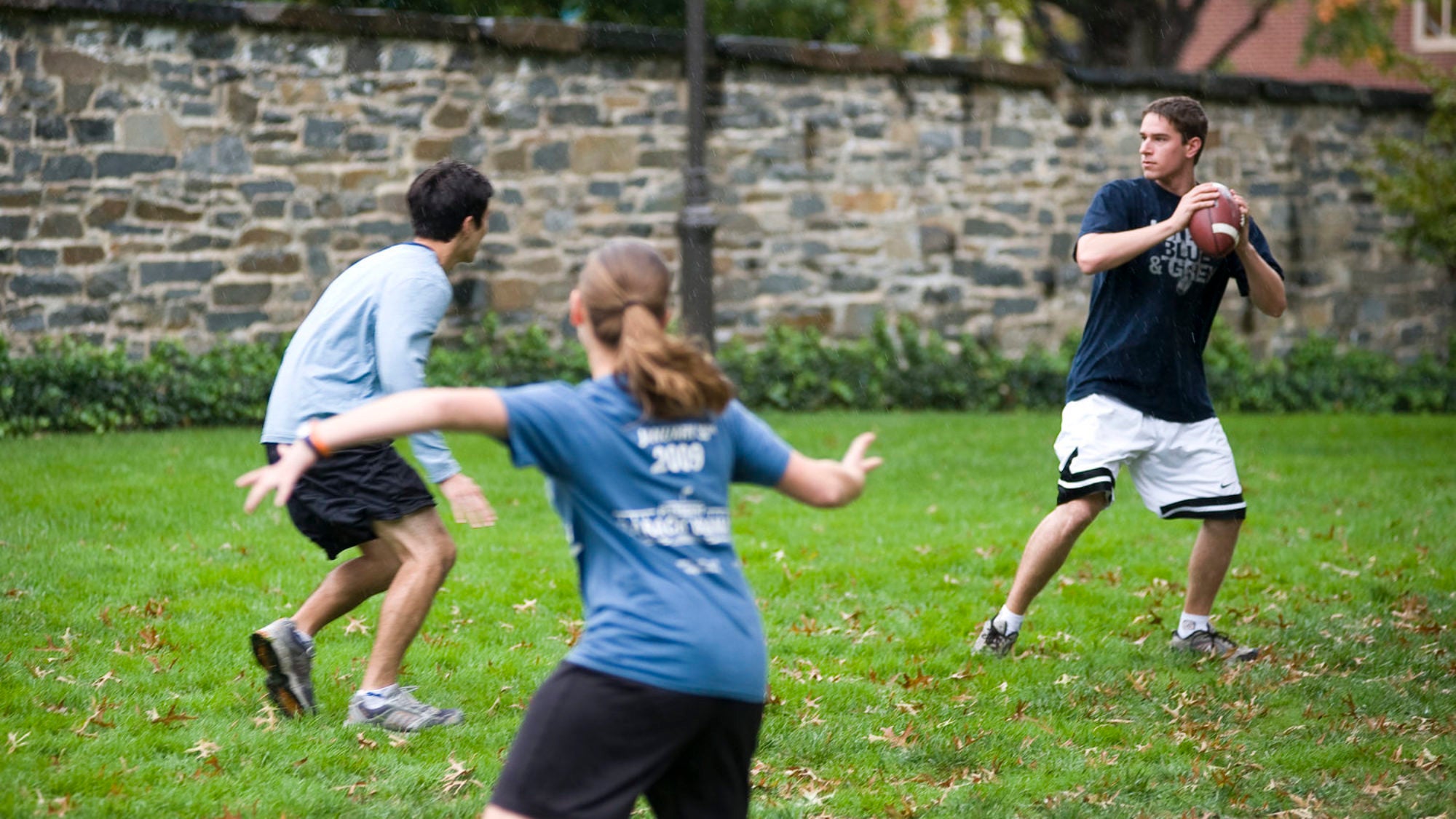 Students play football on the lawn