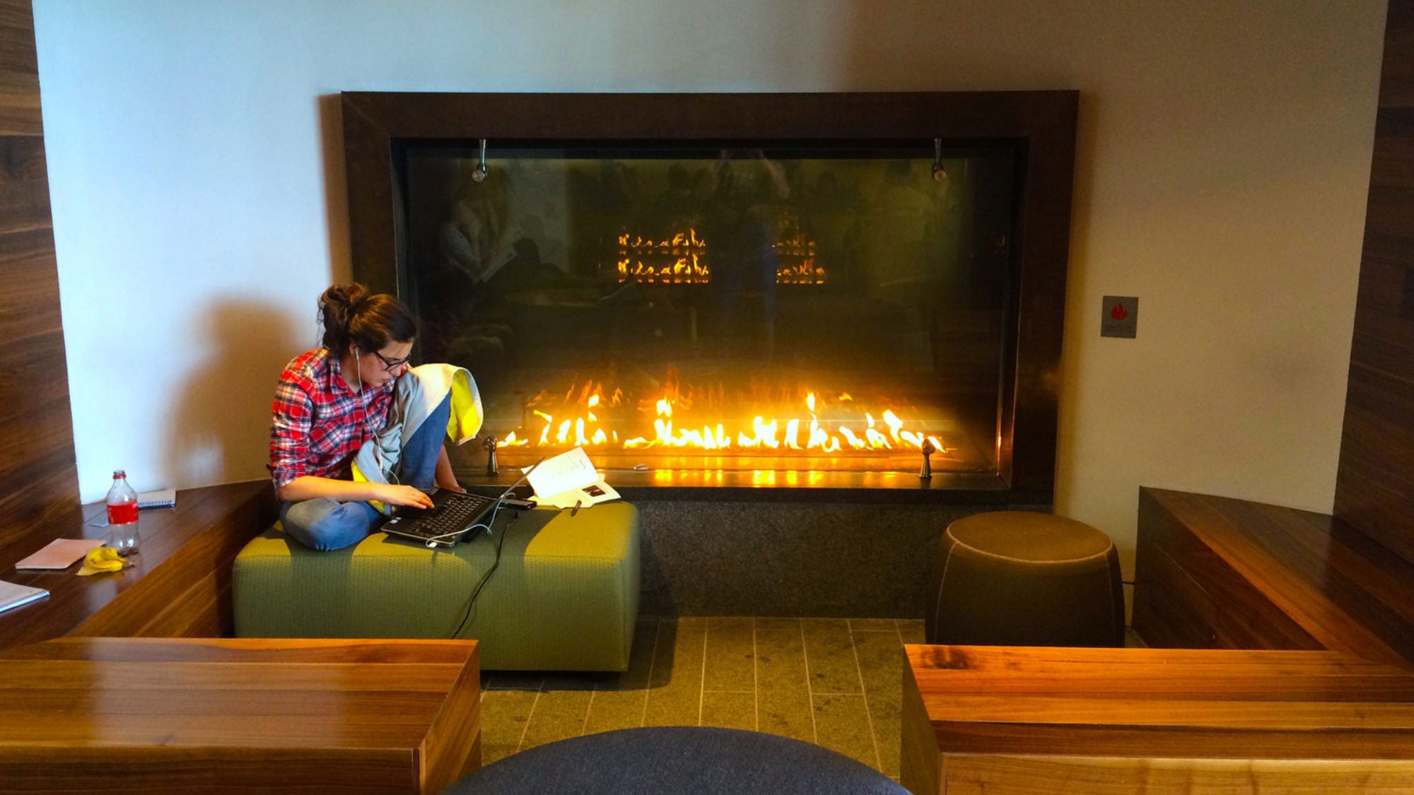 A student works near the fireplace in the Healey Family Student Center