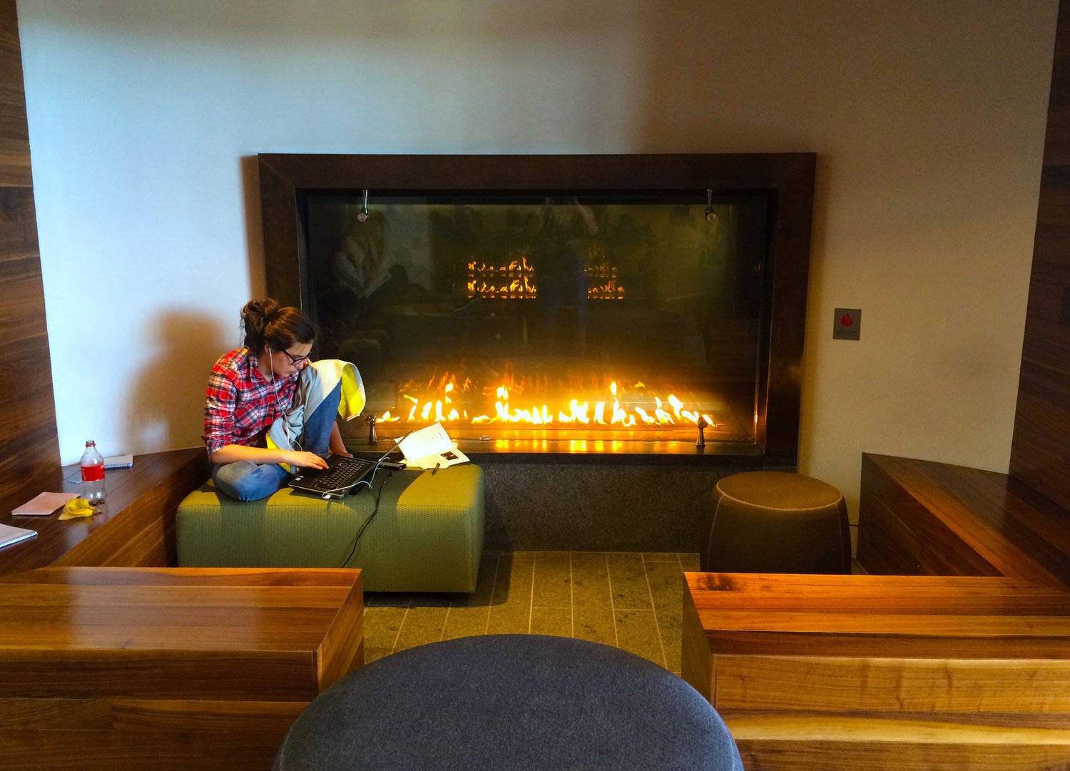 A student works near the fireplace in the Healey Family Student Center