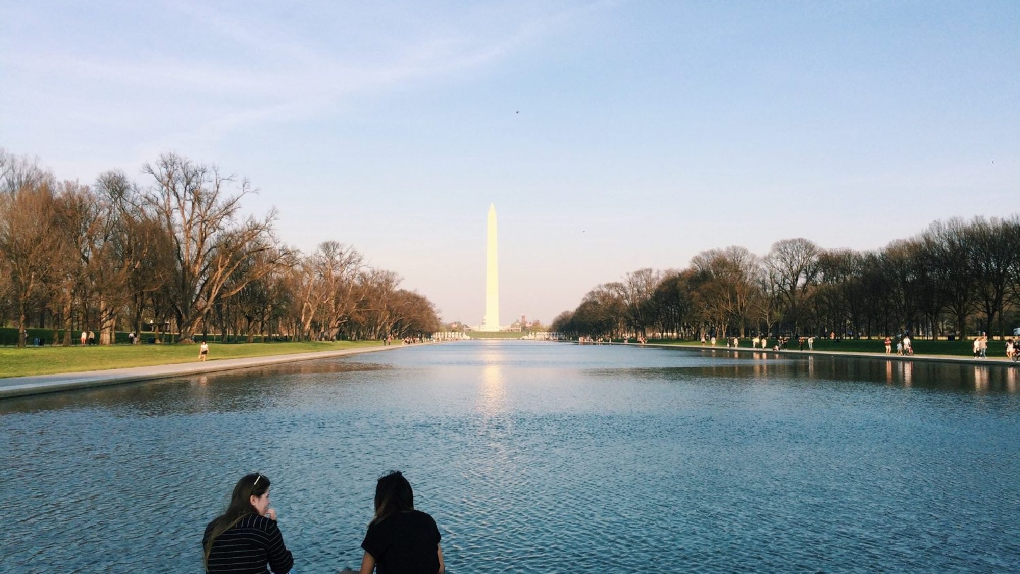 Students sit near the reflecting pool