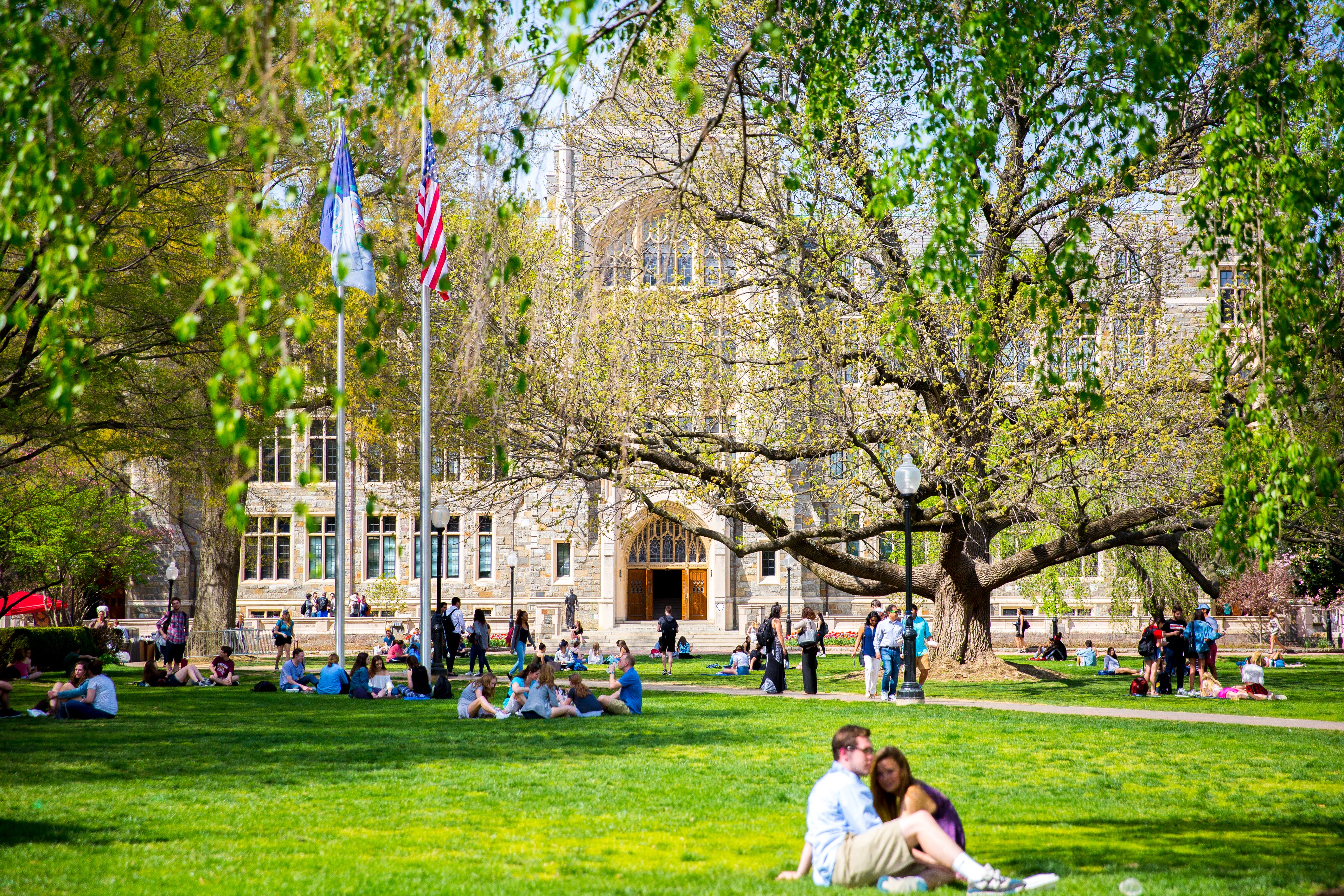 Students lounge on Copley Lawn in front of White Gravenor.