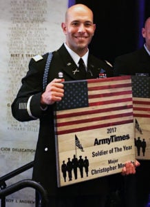 Christopher Mercado stands with his Army Times Soldier of the Year Award.