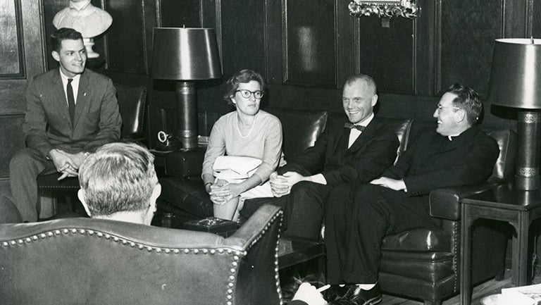 Vera Rubin with John Glenn and other men sitting around in chairs