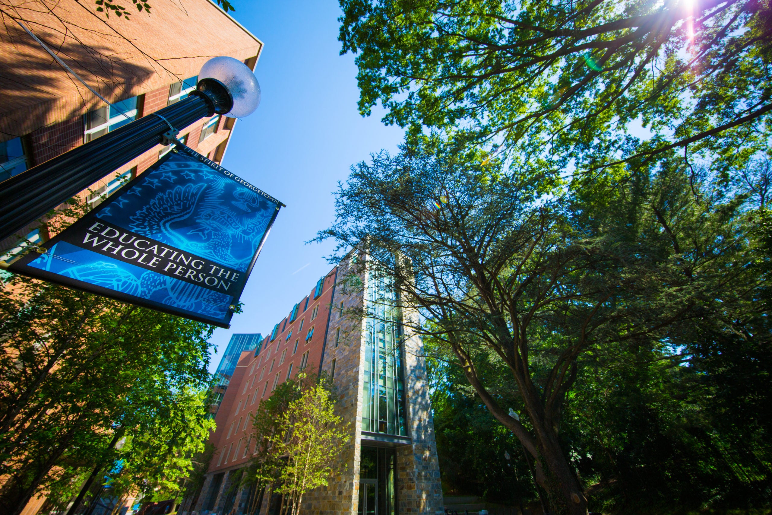 The image shows a banner that says "Educating the Whole Person" which hands in front of Arrupe Hall.