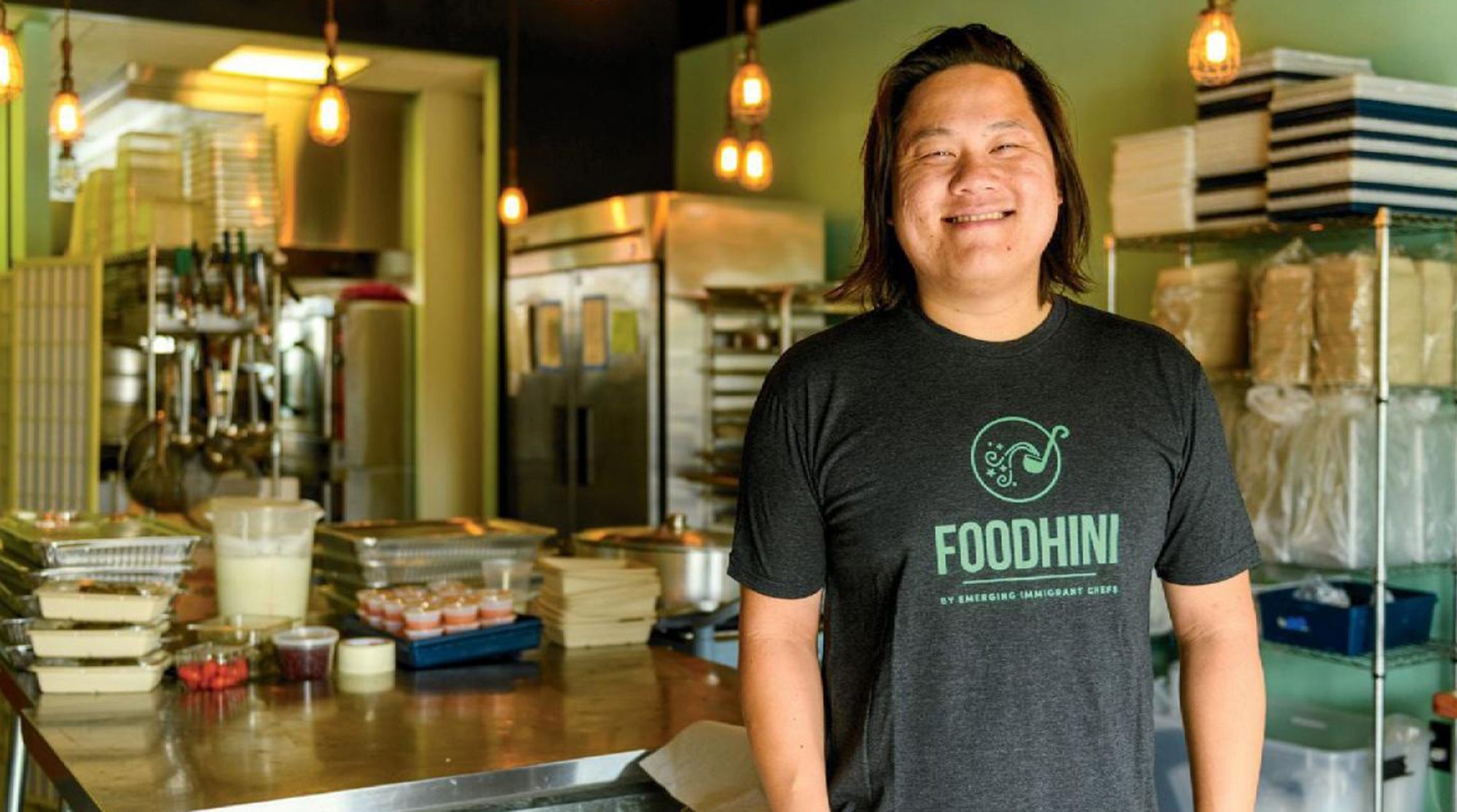 Noobtsaa Philip Vang wearing an apron in his kitchen