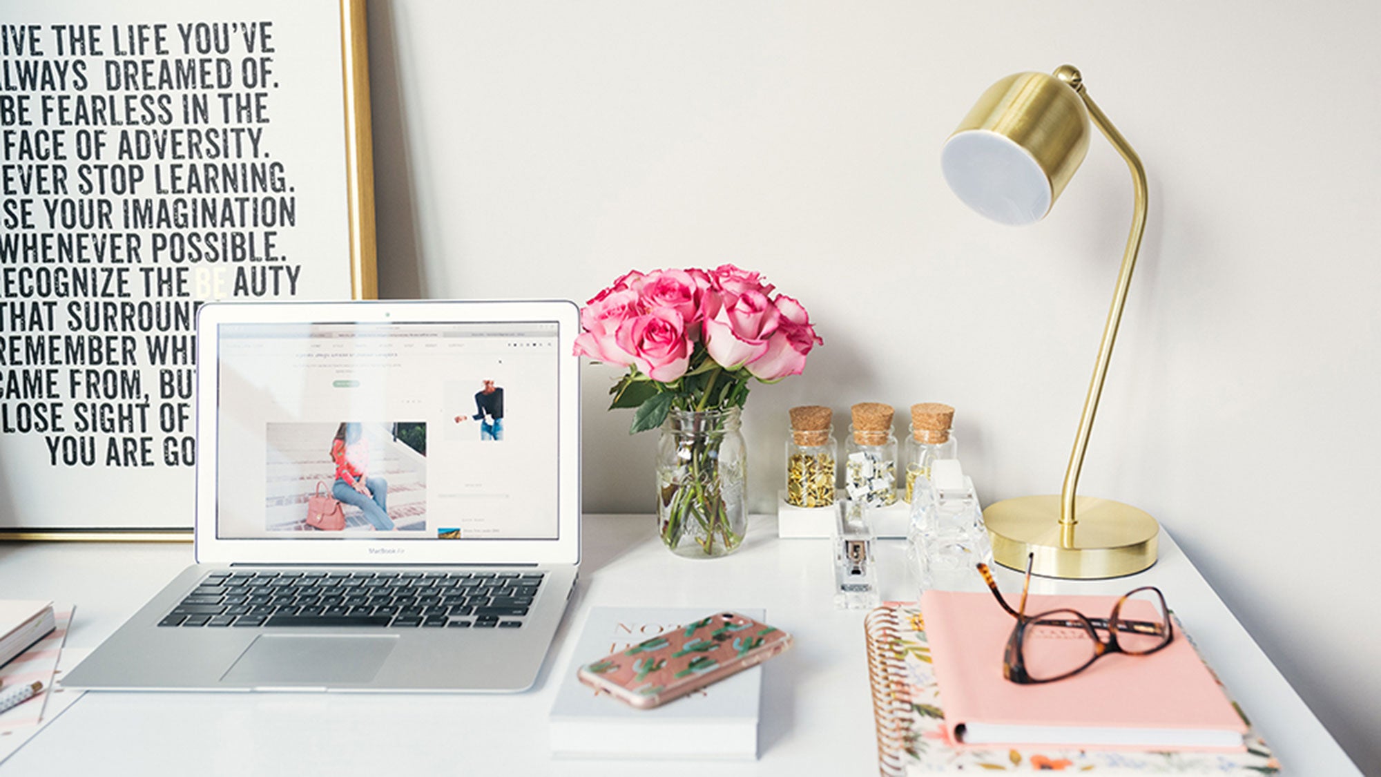 A laptop sits on a desk in a home office.