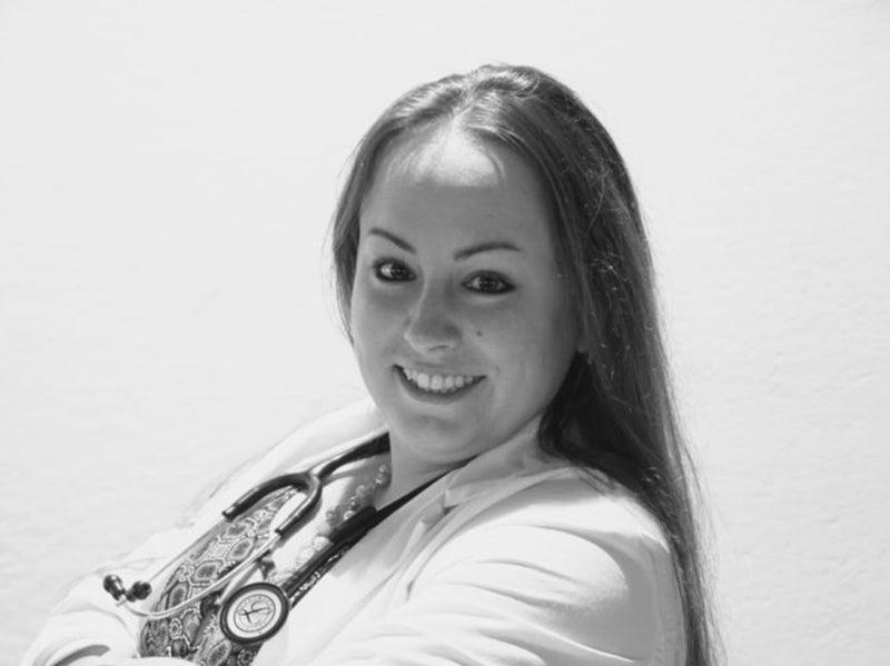 Arielle Tango wearing a white coat and a stethoscope around her neck