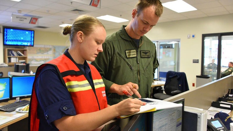 Melissa Cafferty and unidentified man look at a clipboard in an office setting