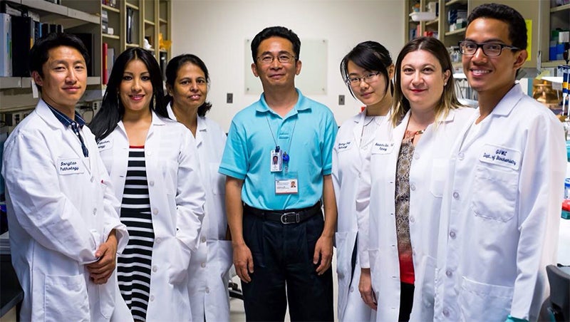 Dr. Xuefeng Liu and his research team stand together in his lab