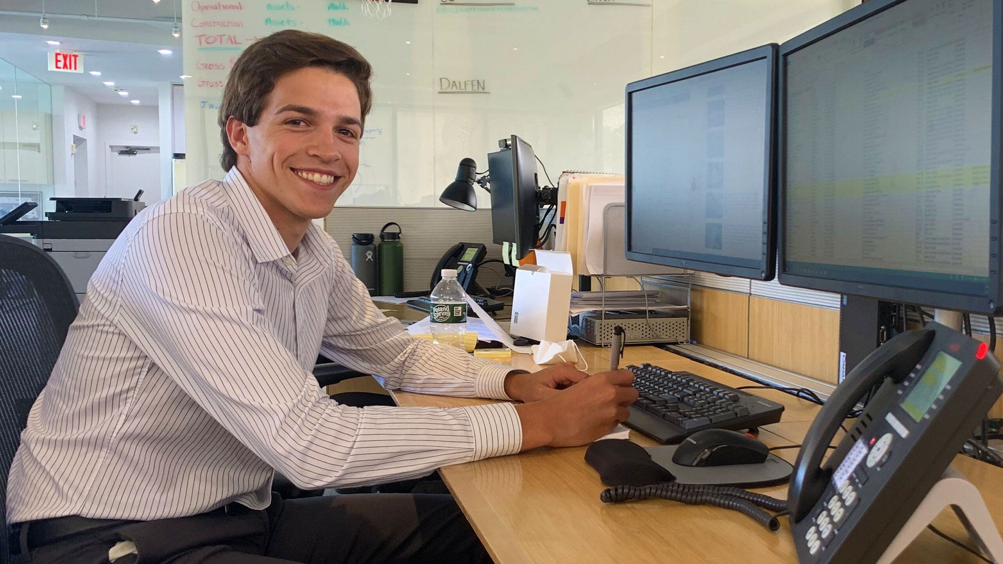 Julien Matrullo sits at a desk and smiles into the camera.