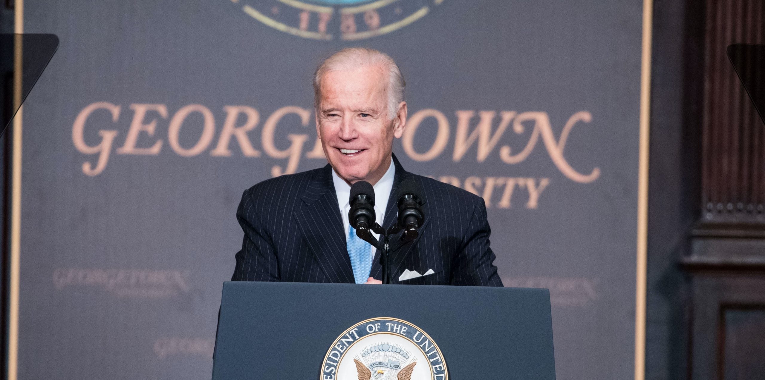 President Joe Biden speaks from a podium with a Georgetown University sign behind him