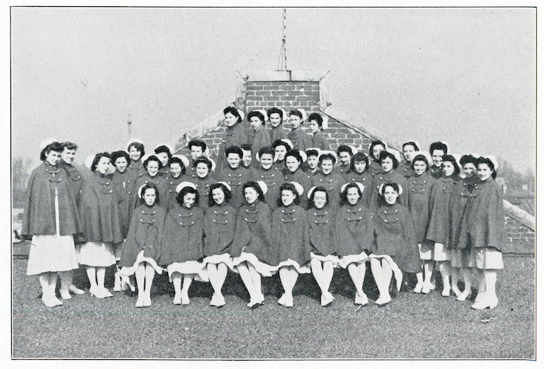 A historic photograph of the Georgetown nursing students in the Cadet Nurse Corps posing together outdoors in nursing uniforms