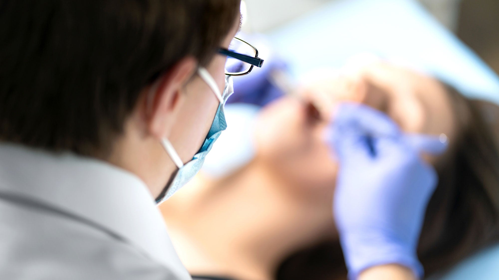 A doctor perforns a surgical procedure on a patient.