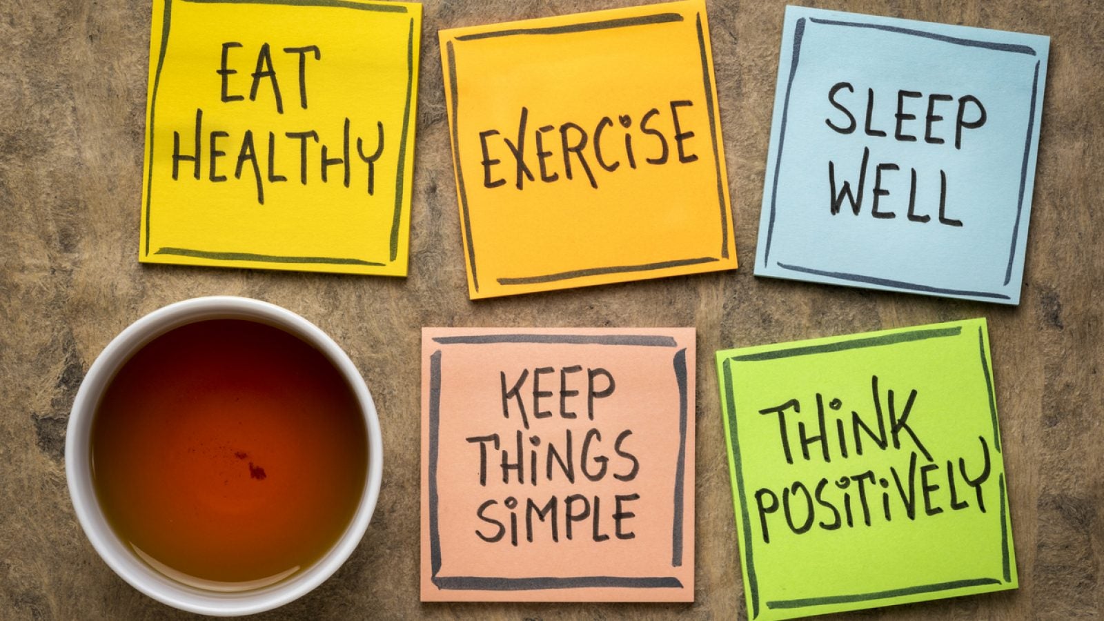 Tea and post-its reading, &quot;Eat Healthy,&quot; &quot;Exercise,&quot; &quot;Sleep Well,&quot; &quot;Keep Things Simple&quot; and &quot;Think Positively&quot;