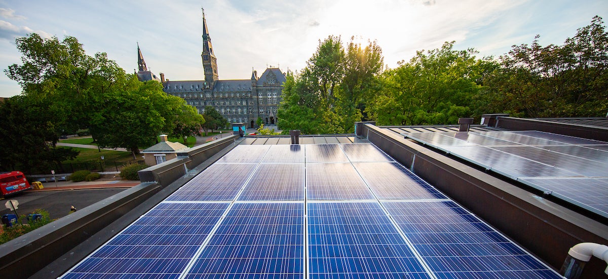 Solar panels on Georgetown townhouse rooftops with Healy Hall in the background