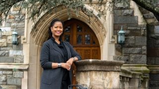 Soyica Diggs Colbert stands in front of a stone building