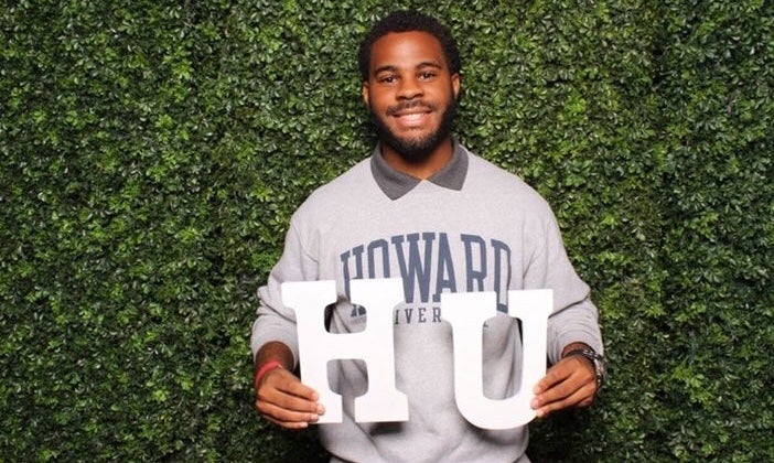 Quentin Byrd wears a Howard sweatshirt and holds "HU" letters