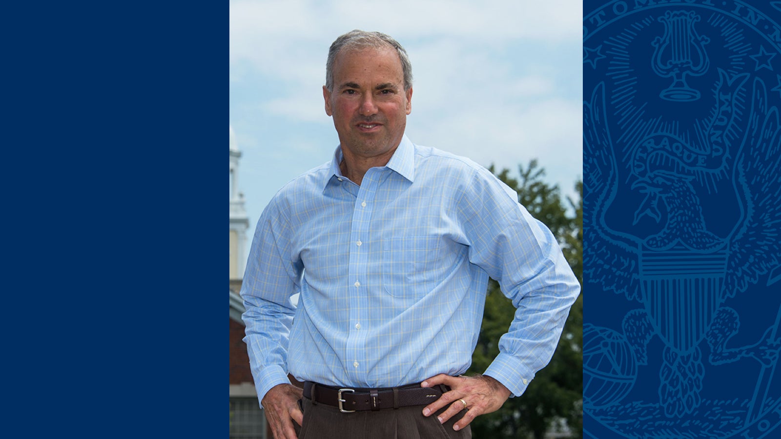 Jesse Goodman wears a blue shirt and stands with his hands on his hips