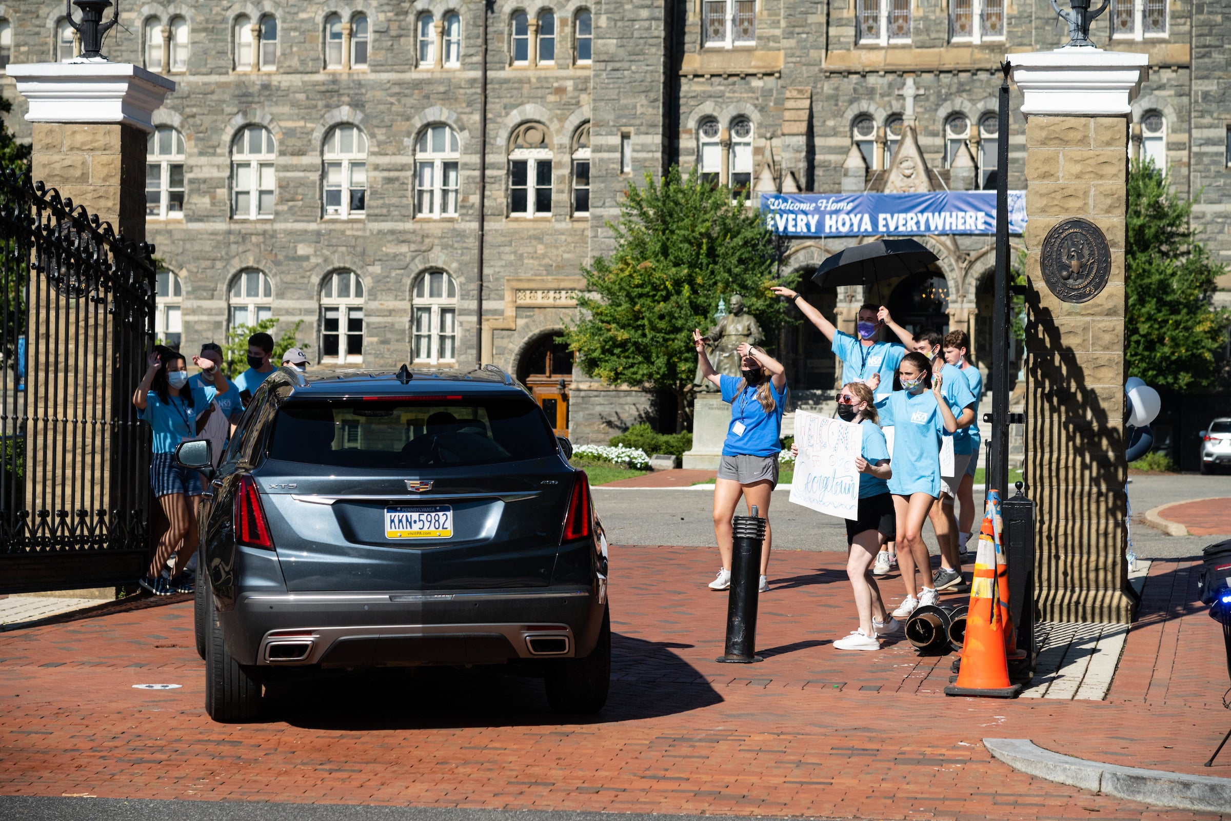 Orientation Advisors cheer as a car drives through the front gates