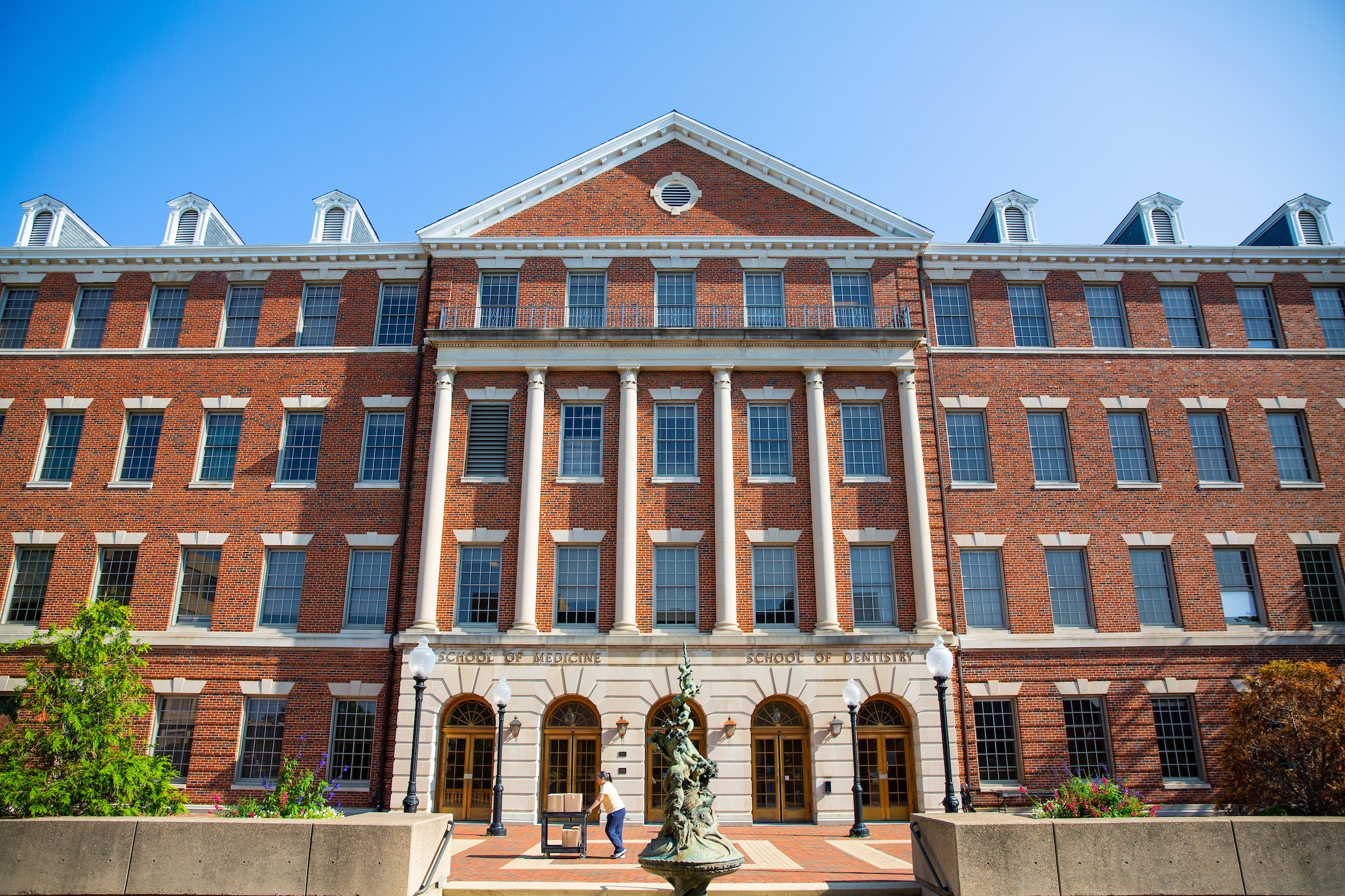 Exterior of brick Med Dent building with several rows of windows and columns down the front