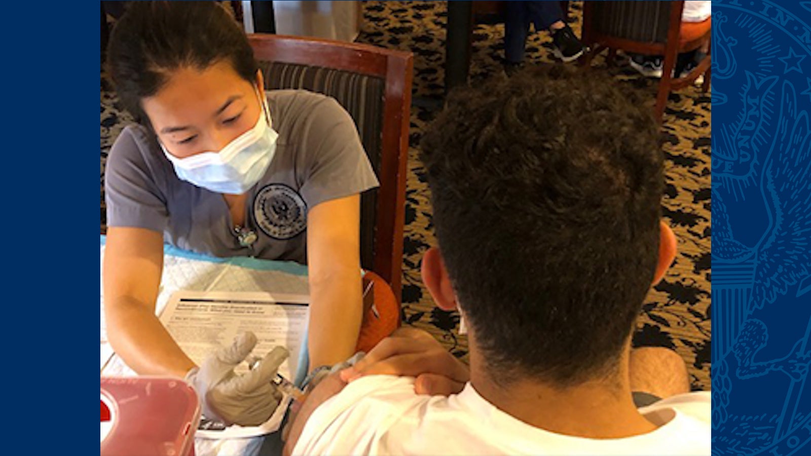 Nursing student wearing a mask gives a flu shot