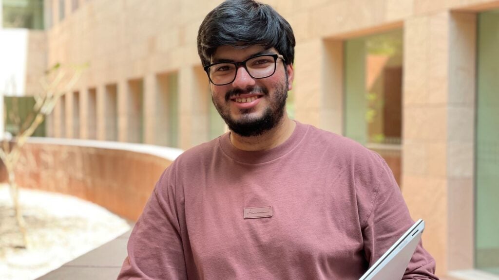 Kartikeya Uniyal wears glasses and a dark pink shirt