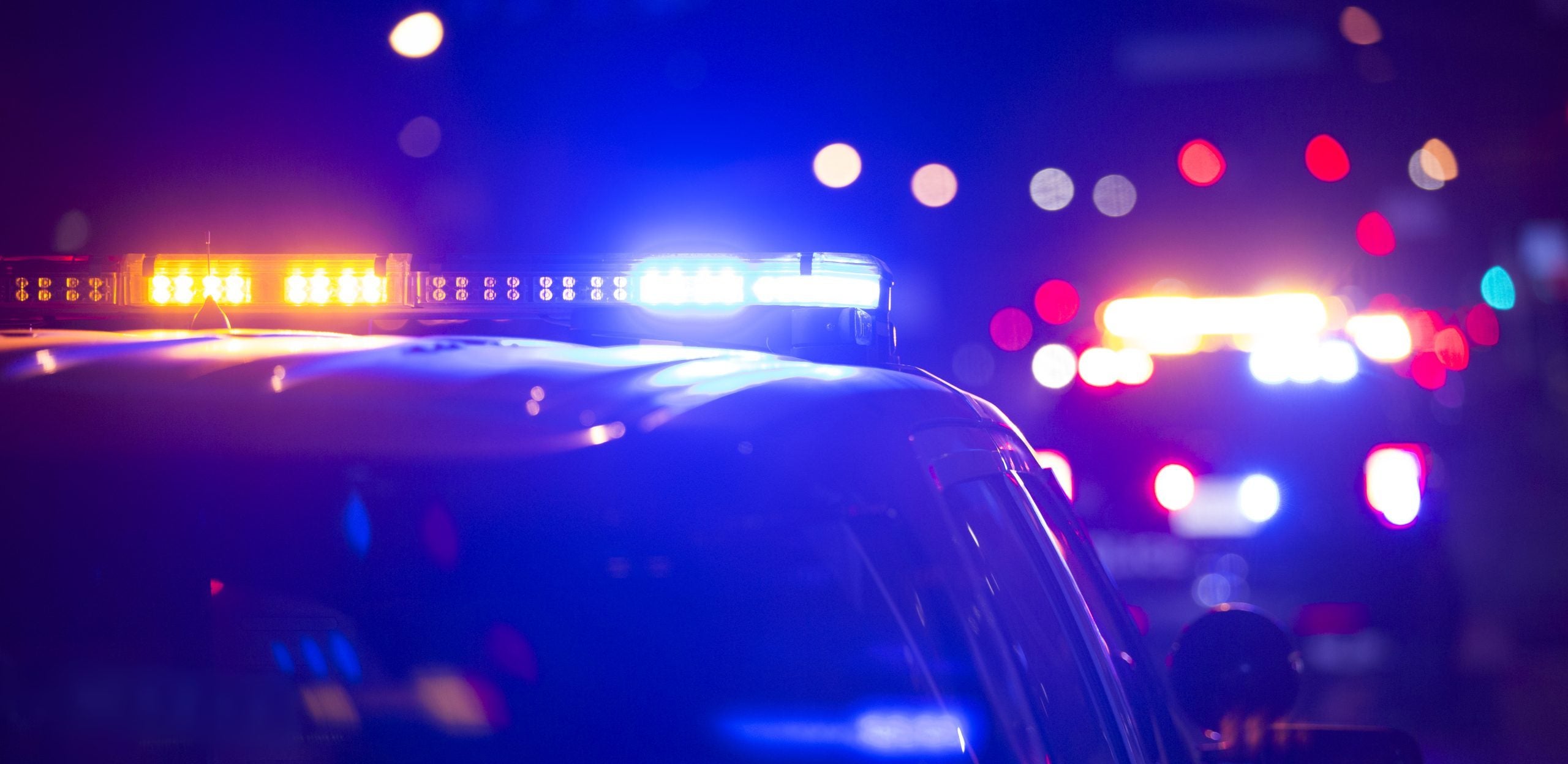 Red and blue sirens of a police car and fire engine at night