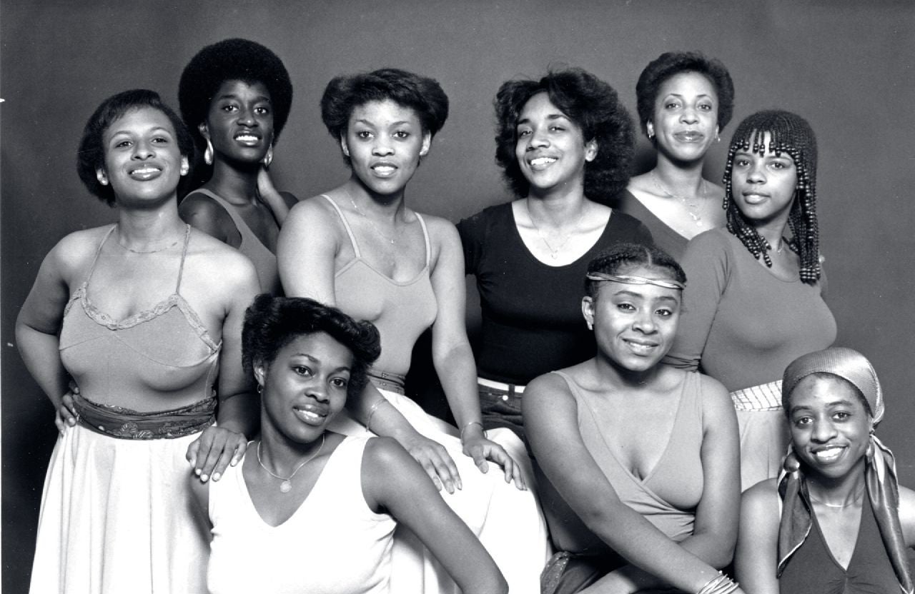 Black and white image of nine women in dance clothes