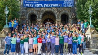 Group photo of Corp employees wearing Corp T-shirts on Healy steps