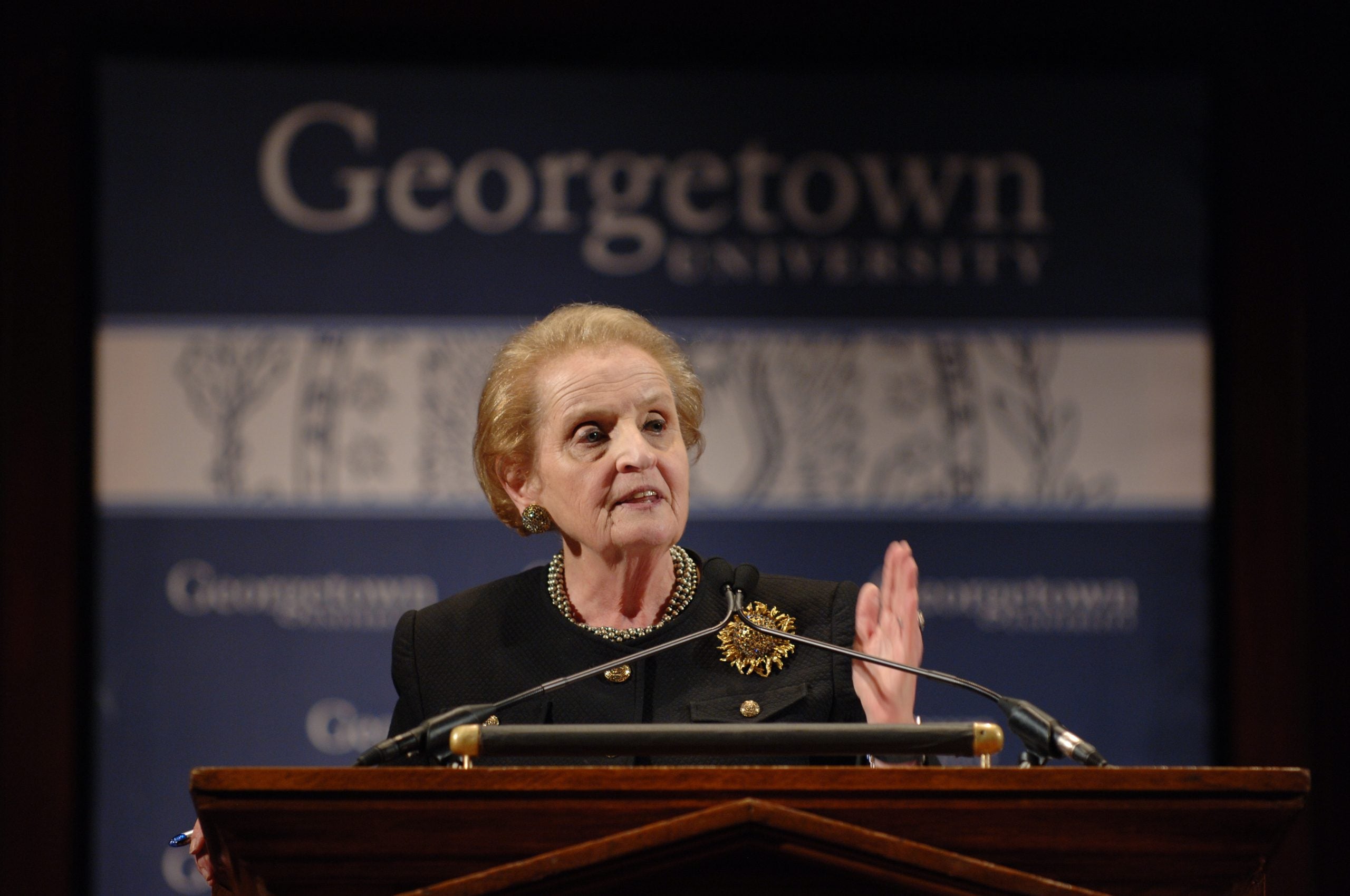 Madeleine Albright speaks behind a podium with a "Georgetown" sign behind her