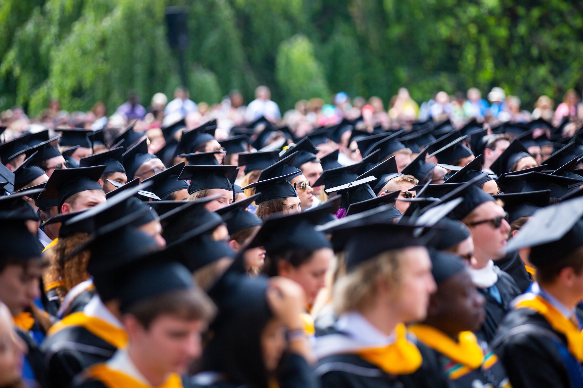 A crowd of students wearing graduation caps and gowns