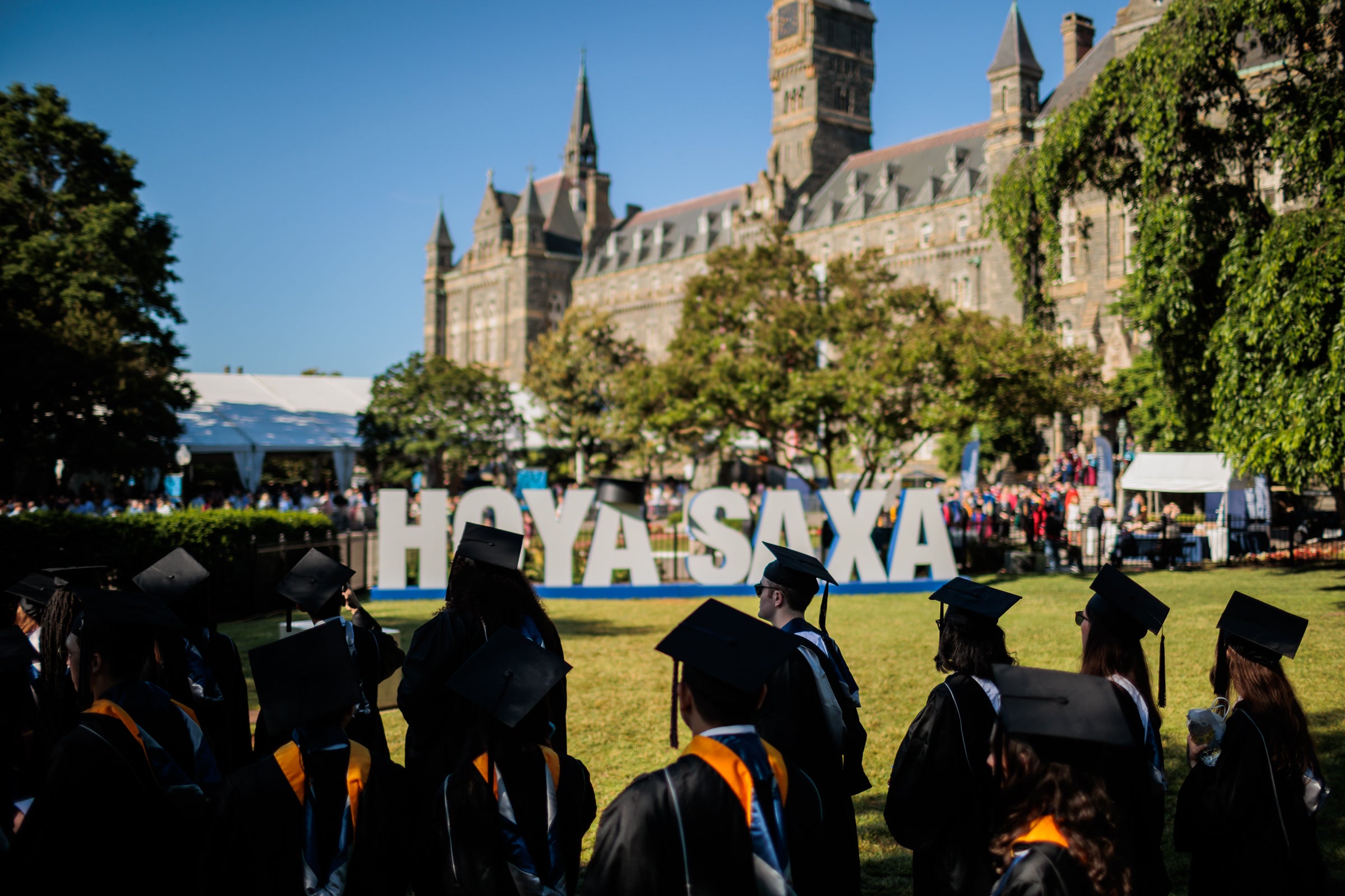 Members of the Class of 2020 process in front of a white Hoya Saxa sign at Georgetown University on May 28.