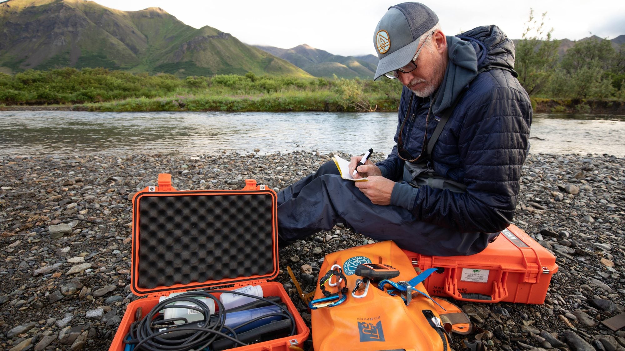 An environmental scientist and Georgetown alumnus conducts research by the side of a river.