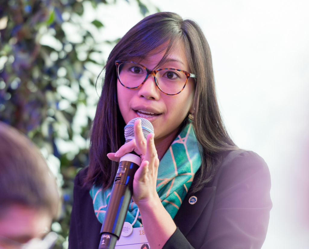 An image of Tiffany Yu (B'10) speaking into a microphone at an event.